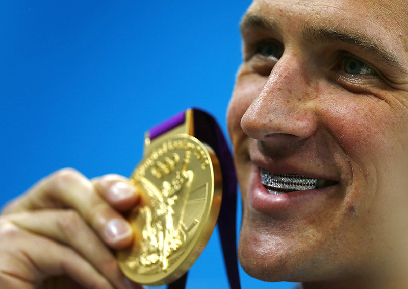 Ryan Lochte shows off his gold medal (and his grill) at the 2012 Olympics in London.